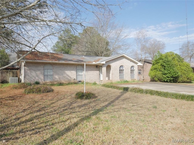 single story home with a front yard and central air condition unit