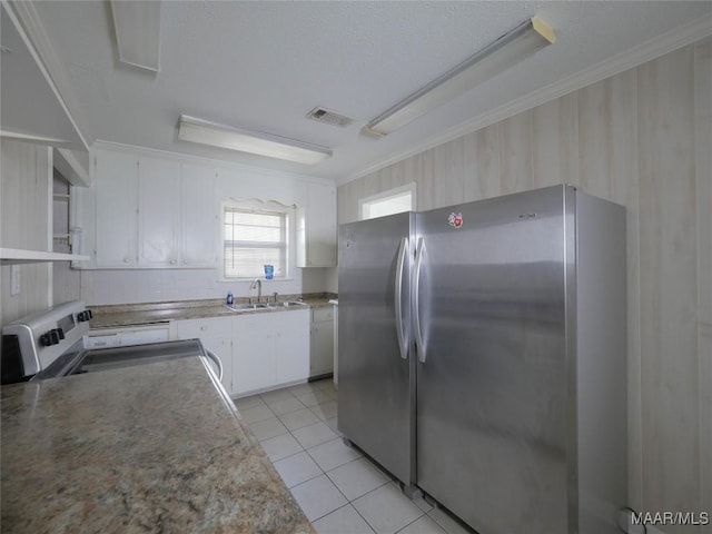 kitchen featuring light tile patterned flooring, appliances with stainless steel finishes, white cabinetry, sink, and crown molding