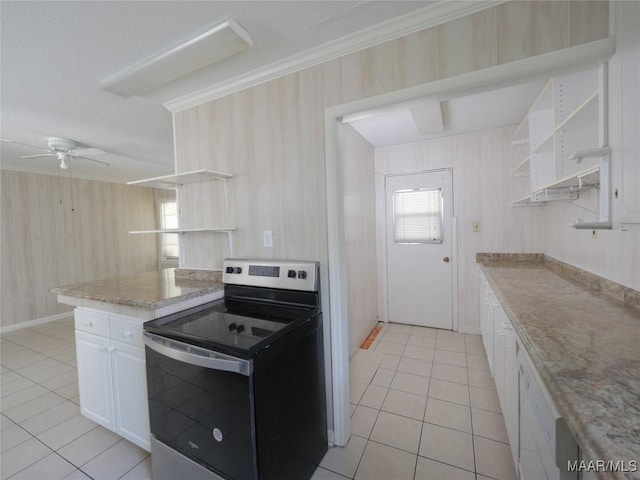 kitchen with light tile patterned floors, ceiling fan, white cabinetry, ornamental molding, and stainless steel electric stove