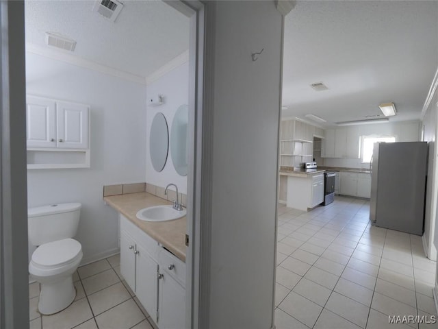 bathroom featuring tile patterned flooring, sink, ornamental molding, and toilet