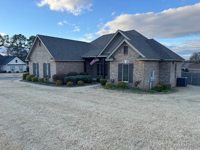 view of front facade featuring a front lawn and central air condition unit