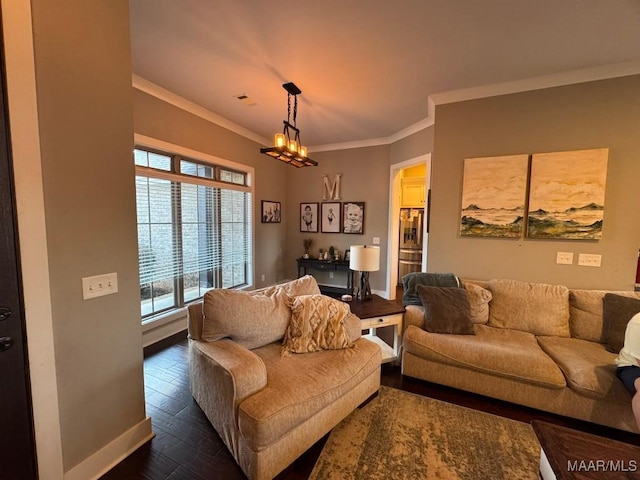 living room with crown molding, a chandelier, and dark wood-type flooring