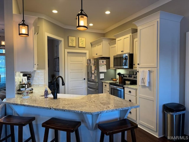 kitchen with pendant lighting, sink, white cabinets, stainless steel appliances, and light stone countertops