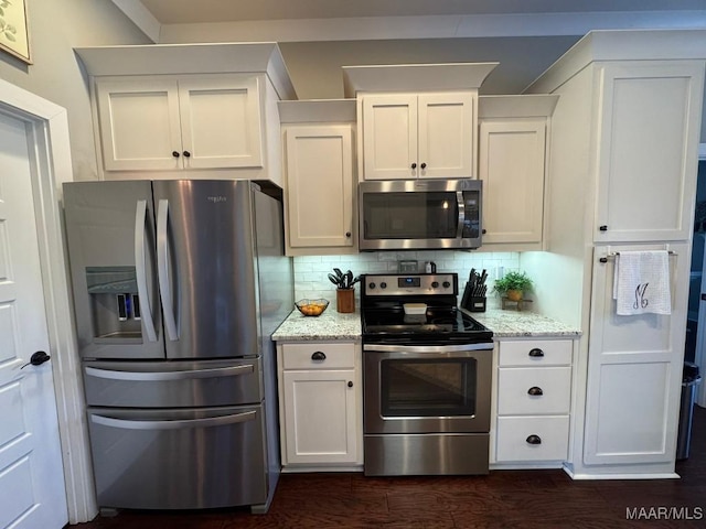 kitchen with stainless steel appliances, backsplash, white cabinets, and light stone counters