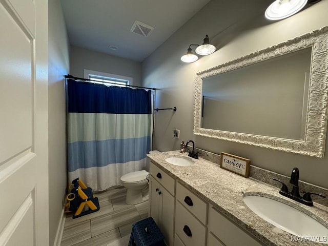 bathroom with vanity, a shower with shower curtain, and toilet