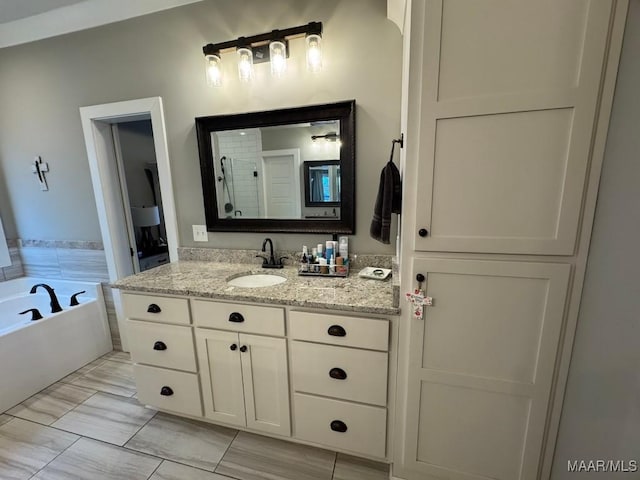 bathroom featuring a washtub and vanity