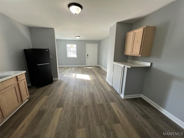 kitchen featuring dark wood-type flooring and black fridge