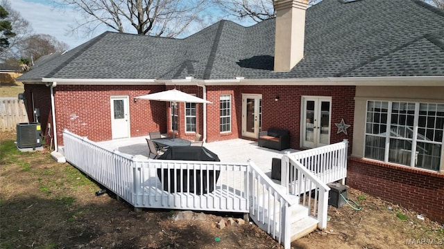 rear view of property with a wooden deck, cooling unit, and french doors