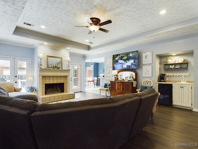 living room featuring a raised ceiling, dark hardwood / wood-style floors, and a textured ceiling