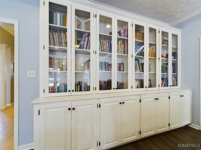 interior details featuring hardwood / wood-style flooring, ornamental molding, and a textured ceiling