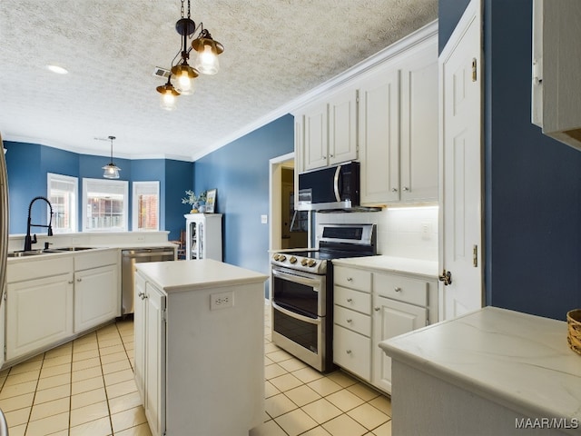 kitchen featuring sink, appliances with stainless steel finishes, a kitchen island, pendant lighting, and white cabinets