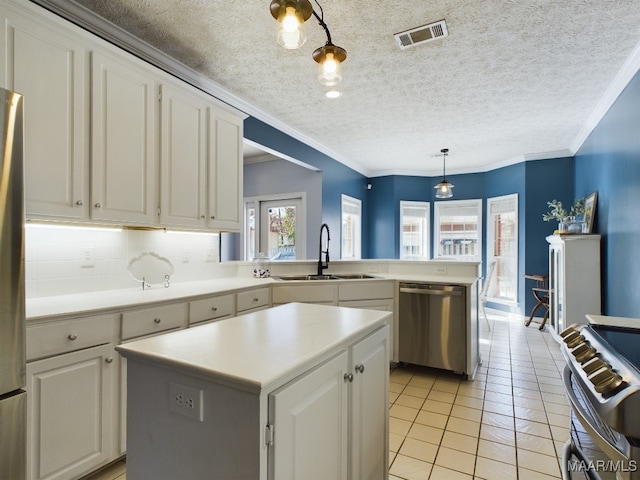 kitchen with appliances with stainless steel finishes, a center island, pendant lighting, and white cabinets