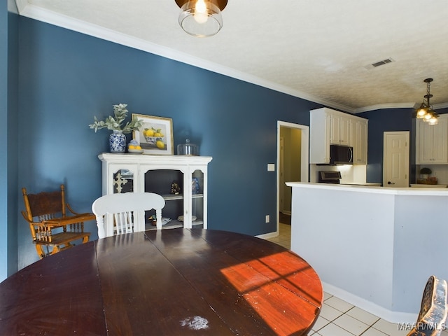 tiled dining area featuring ornamental molding