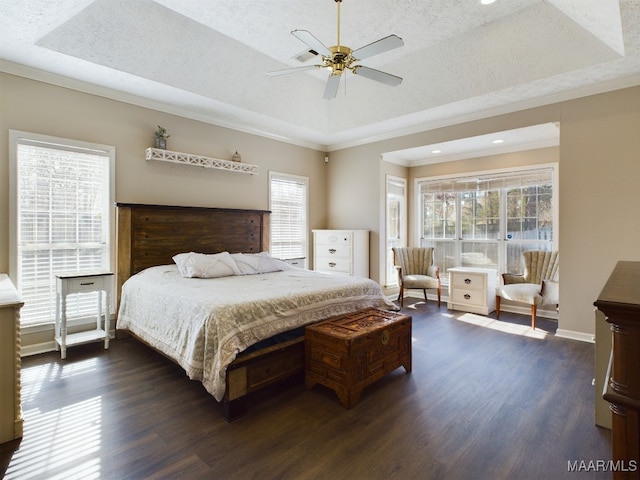 bedroom featuring dark wood-type flooring, a tray ceiling, a textured ceiling, and crown molding