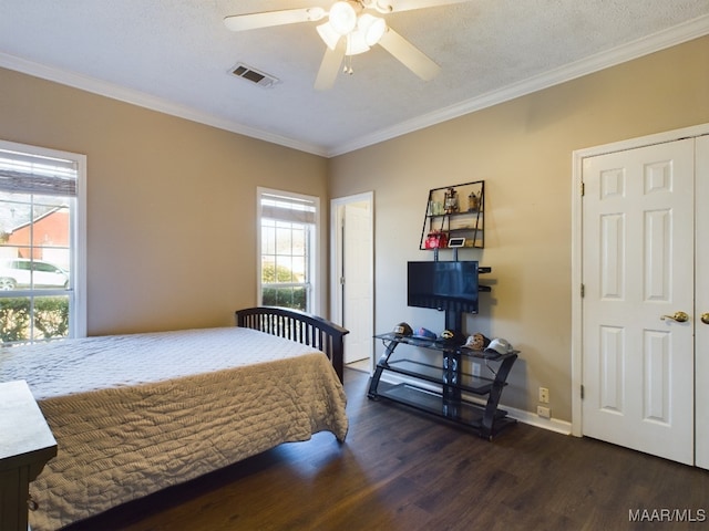 bedroom featuring ceiling fan, ornamental molding, dark hardwood / wood-style floors, and a textured ceiling