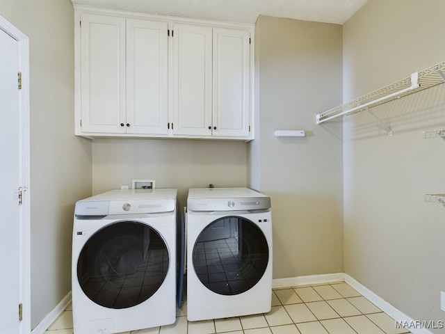 washroom featuring cabinets, washer and dryer, and light tile patterned flooring