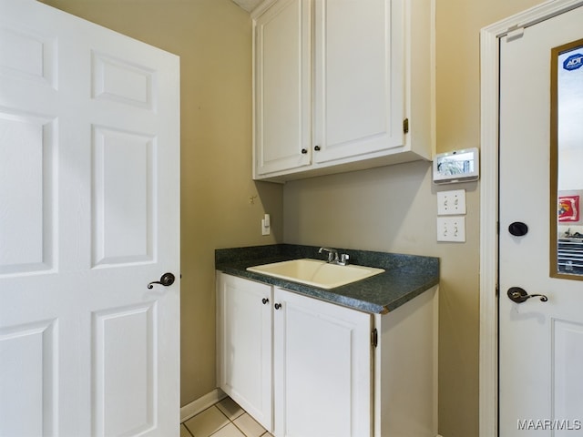 laundry room featuring sink and light tile patterned floors