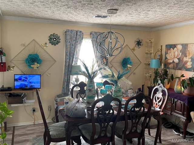 dining room featuring ornamental molding, hardwood / wood-style floors, and a textured ceiling