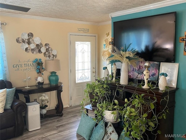 foyer featuring crown molding, wood-type flooring, and a textured ceiling