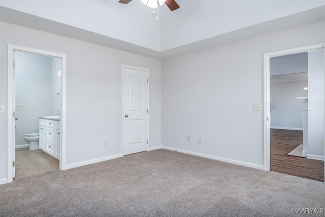 unfurnished bedroom featuring ensuite bathroom, light carpet, and ceiling fan