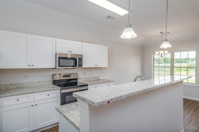 kitchen featuring white cabinetry, light stone counters, a center island, hanging light fixtures, and stainless steel appliances