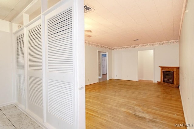 interior space with ornamental molding and light hardwood / wood-style floors