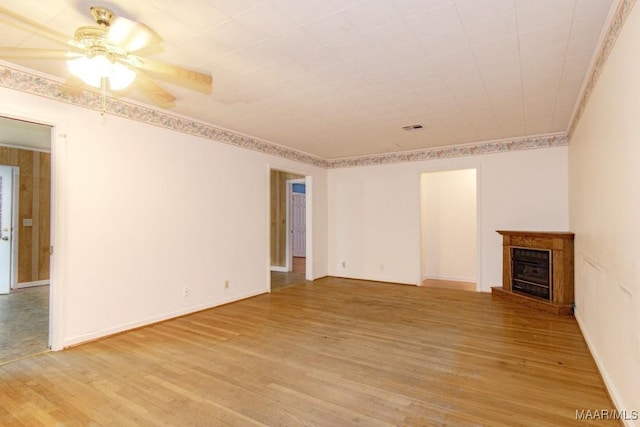 spare room featuring ceiling fan, ornamental molding, and light wood-type flooring