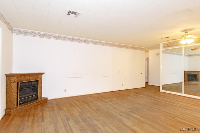 unfurnished living room with hardwood / wood-style flooring and ceiling fan