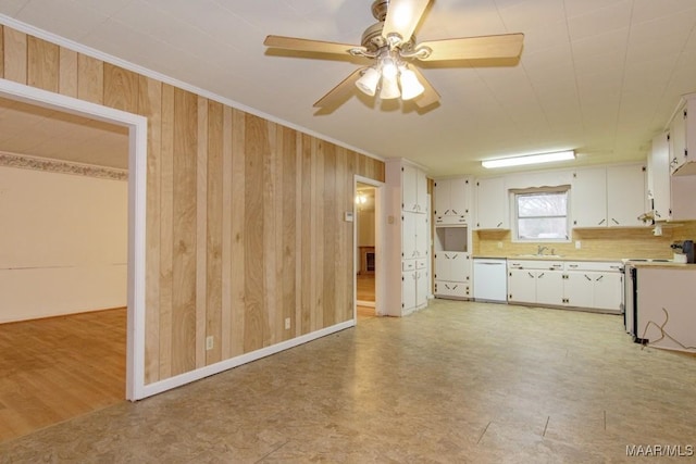 kitchen featuring sink, dishwasher, electric range, white cabinets, and wooden walls