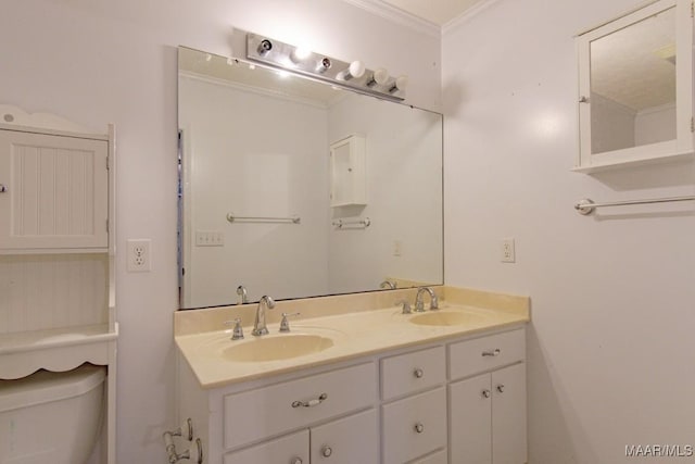 bathroom with toilet, vanity, and crown molding