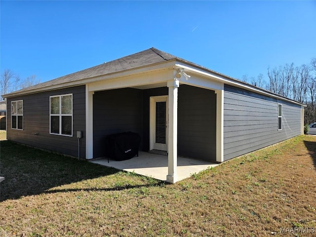 view of home's exterior with a patio and a lawn