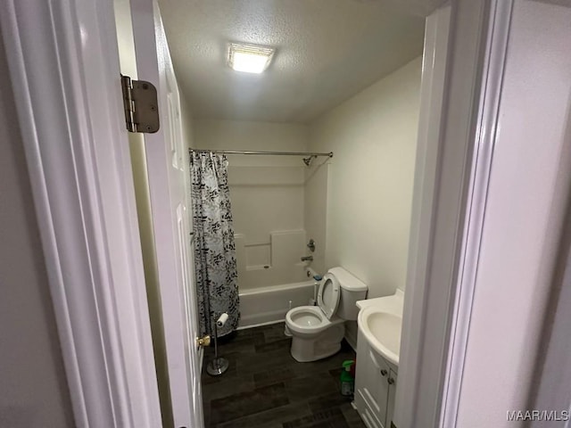 full bathroom with toilet, shower / bath combo with shower curtain, wood-type flooring, a textured ceiling, and vanity