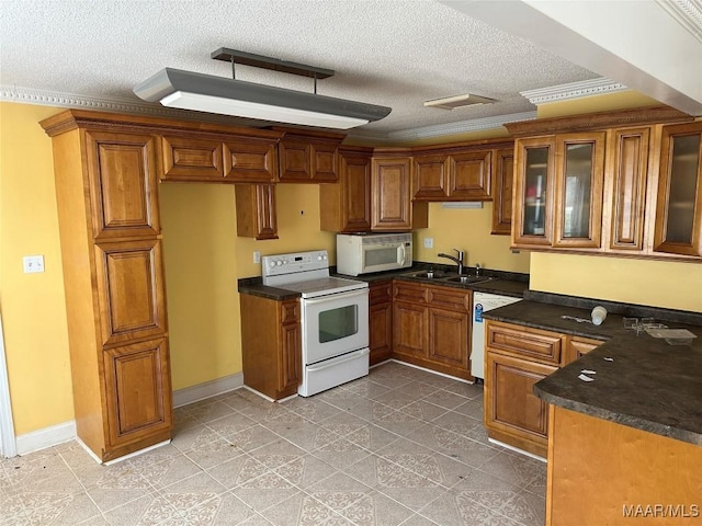 kitchen featuring white appliances, a textured ceiling, sink, and ornamental molding