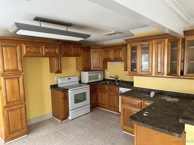 kitchen featuring sink, white appliances, a textured ceiling, dark stone counters, and crown molding