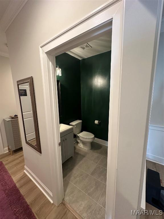 bathroom with toilet, baseboards, wood finished floors, and vanity