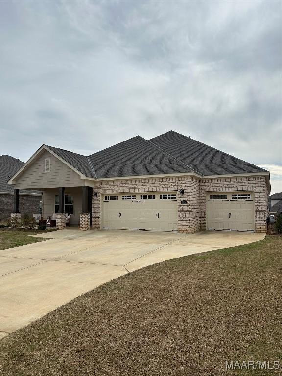 view of front facade with concrete driveway, brick siding, an attached garage, and roof with shingles