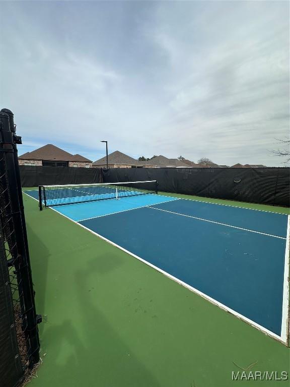 view of tennis court with fence