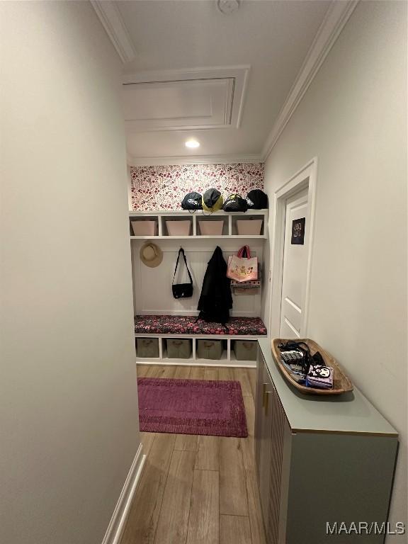 mudroom featuring ornamental molding, wood finished floors, and attic access