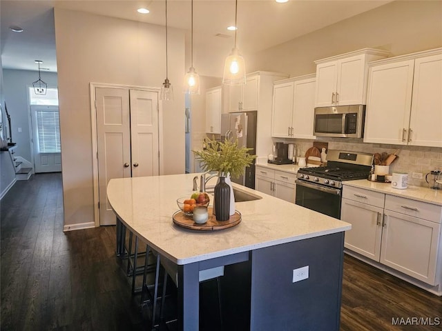 kitchen featuring an island with sink, white cabinetry, and stainless steel appliances