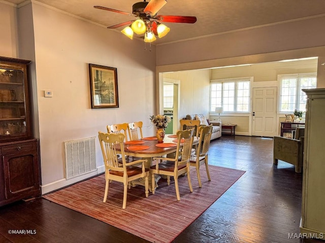 dining space featuring ornamental molding, dark wood-type flooring, and ceiling fan