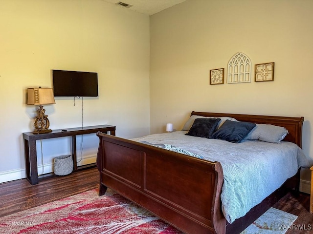 bedroom featuring baseboard heating and dark wood-type flooring