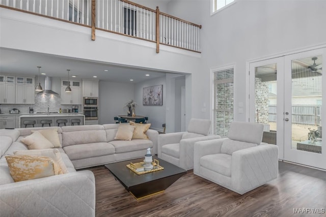 living room with french doors, sink, dark hardwood / wood-style floors, and a towering ceiling