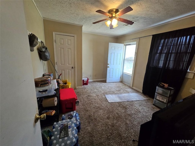 foyer with ceiling fan, crown molding, carpet flooring, and a textured ceiling