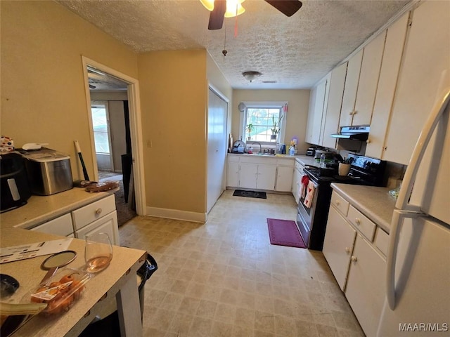 kitchen featuring white cabinetry, electric range oven, white fridge, and a textured ceiling