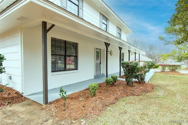 view of home's exterior featuring covered porch and a lawn