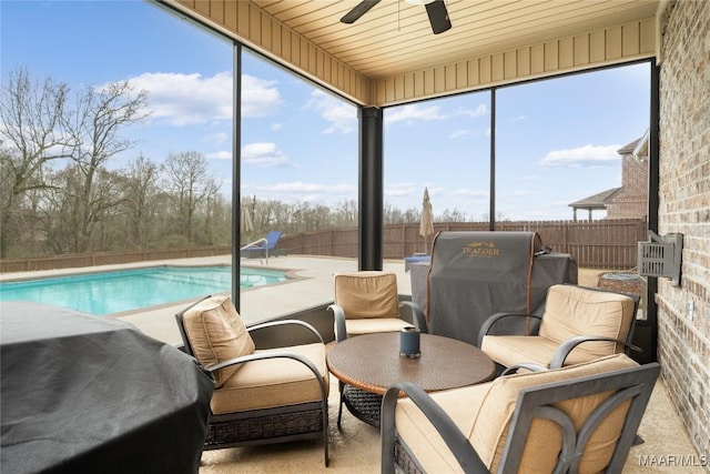 sunroom with ceiling fan, plenty of natural light, and wood ceiling