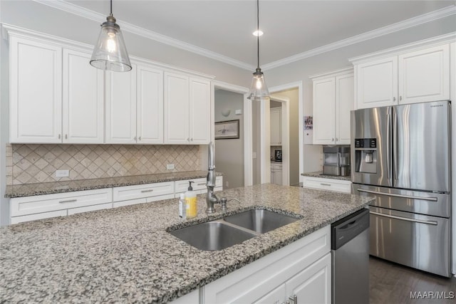 kitchen with appliances with stainless steel finishes, white cabinets, light stone countertops, and decorative light fixtures