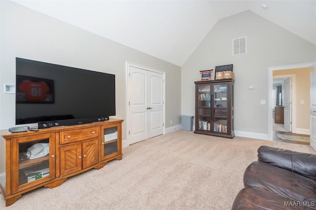 carpeted living room featuring high vaulted ceiling