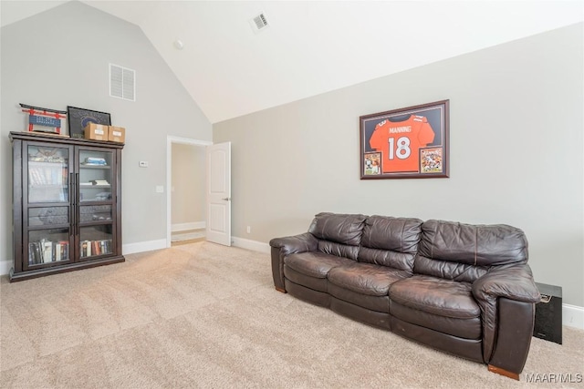 living room with high vaulted ceiling and light colored carpet