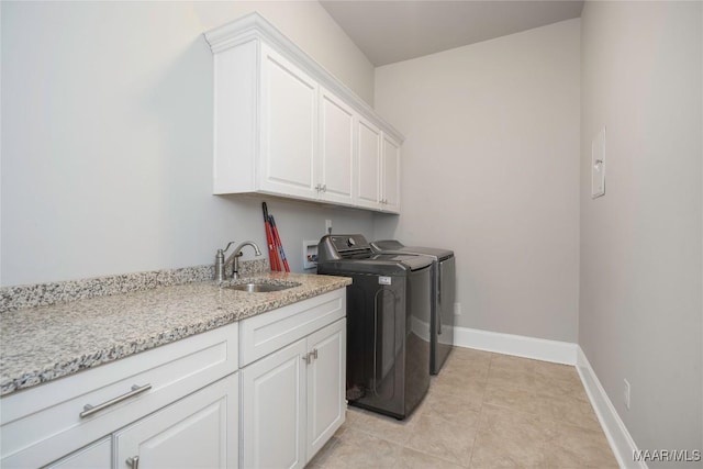 washroom with sink, cabinets, light tile patterned flooring, and washer and clothes dryer